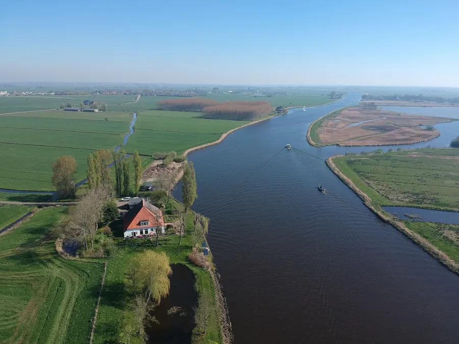Vrijzicht aan het Prinses Margrietkanaal, met de Friese weilanden en het water tot aan de horizon, vanuit de lucht